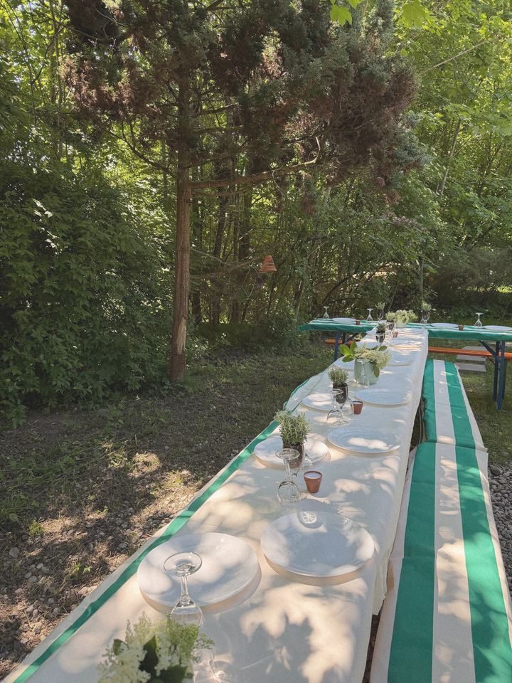 Lange Tafel mit grün-weißen Bankauflagen